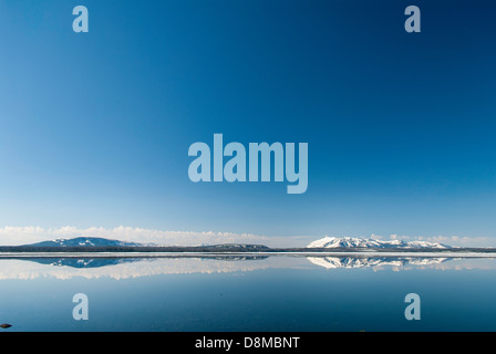 Die roten Berge erheben sich über das Blau des Yellowstone Lake im südlichen Yellowstone National Park. Stockfoto