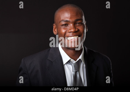 hübscher junger afrikanischer Geschäftsmann auf schwarzem Hintergrund Stockfoto