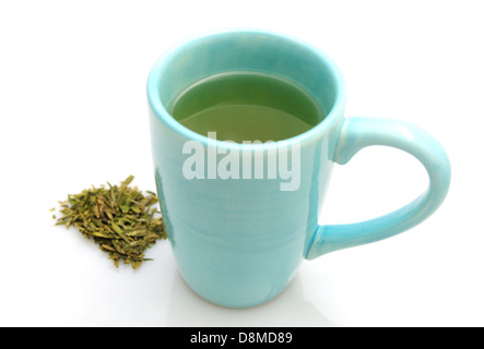 Warmen Tee in blauen Becher mit grünem Tee Blätter isolierten auf weißen Hintergrund Stockfoto