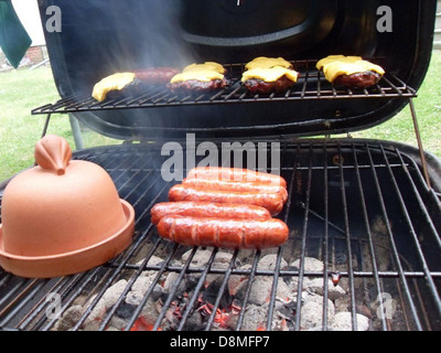 Dieses Stockfoto zeigt eine Nahaufnahme von geräucherten Burgern auf einem Grill, die das herzhafte Aussehen und die satte Farbe des gekochten Fleisches zeigen. Das Bild zeigt den Grillprozess und das köstliche, rauchige Aroma der Burger. Stockfoto