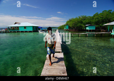 Mann zu Fuß über die Holzbrücke im Coral Cay restaurant Stockfoto