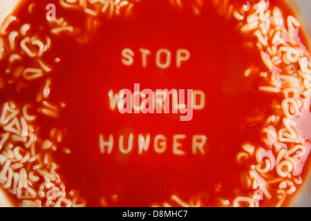 Tomatensuppe mit Nudeln Buchstaben Meldung "stop Hunger in der Welt" Stockfoto