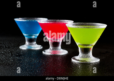 hellen Mini Martinis serviert auf einem nassen dunklen bar oben für einen dramatischen Effekt Stockfoto