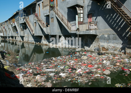 Liu Lu, Einheimische Bewohner, steht auf einem Balkon über einen stark verschmutzten Fluss von Müll und industriellem Abwasser in Shengfang. Stockfoto