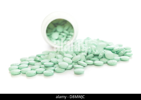 Verschreibungspflichtige Medikamente - grüne Tabletten aus einer weißen Kunststoff Verschreibung Flasche. Flachen DOF, Fokus auf Vordergrund. Stockfoto