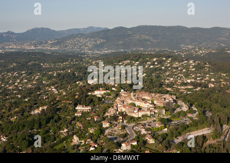 LUFTAUFNAHME. Mittelalterliches Dorf auf dem Hügel von Mougins mit der Stadt Cannes in der Ferne. Französische Riviera, Alpes-Maritimes, Frankreich. Stockfoto