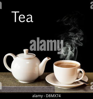 Tee-Konzept - eine heiße, dampfende Tasse Tee mit einer Teekanne auf das Wort "Tee" in weiß auf schwarzem Hintergrund. Stockfoto