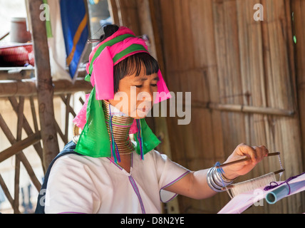 Karen Padong Tribeswoman, eine burmesische Flüchtlinge aus Myanmar, Weben in einem Dorf in der Nähe von Chiang Rai, Nordthailand, Stockfoto