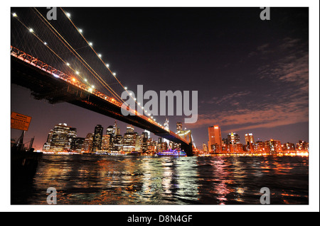 Nachtansicht der Brooklyn Bridge über den East River in Richtung untere Manhattan, New York suchen. Stockfoto