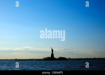 Die Freiheitsstatue in New York City Silhouette gegen den Sommerhimmel, erschossen von der Staten Island Ferry Stockfoto