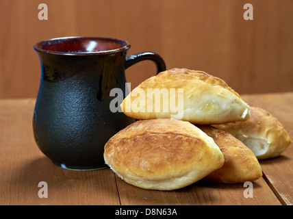 Russland-Traditionen-Piroggen. Home-Kuchen mit Kohl gegen den Holztisch Stockfoto