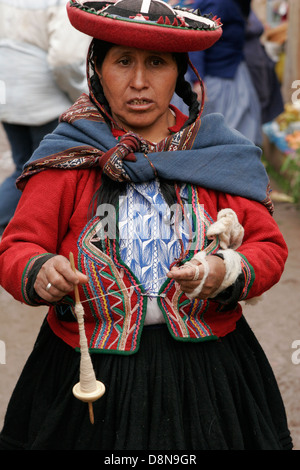 Quechua-Frau Wolle Spinnen von hand gekleidet in traditionellen runden Hut am Sonntag Indiomarkt in Chinchero in der Nähe von Cuzco, Peru Stockfoto