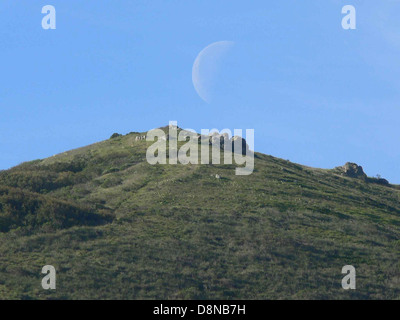 Der Mond aufgeht über Berggipfel und San Bruno. Stockfoto