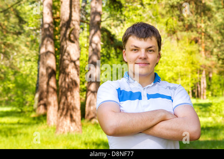 Zuversichtlich Lächeln glücklichen hübschen jungen Mann im Sommer (Frühling) sonnigen Park (Wald). Outdoor-Nahaufnahme Hochformat. Stockfoto