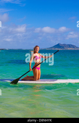 schöne Blondine im Bikini am Paddel board Stockfoto