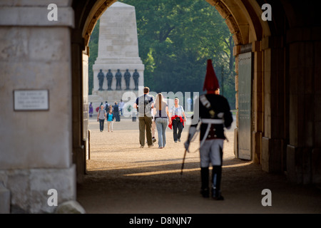 Ein paar Spaziergang durch Horse Guards Parade, London, UK, mit einem uniformierten Horse Guard im Vordergrund. Stockfoto