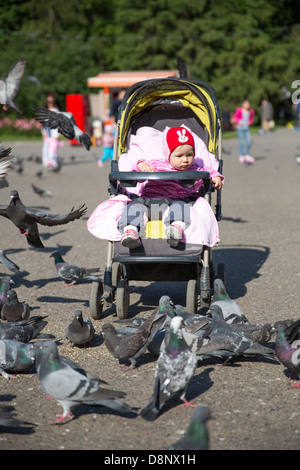 Kind Mädchen spielen mit Tauben in der Stadtstraße Stockfoto