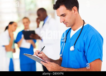 männlichen medizinischen Arbeitnehmer schriftlich Bericht im Krankenhaus Stockfoto