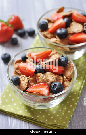 Glass bowl with healthy muesli and fresh berries on a wooden background Stockfoto