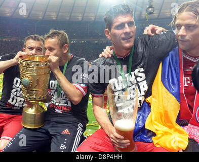 München Rafinha (L-R), Xherdan Shaqiri, Mario Gomez und Anatoliy Tymoshchuk feiern mit der Trophäe nach dem Gewinn der deutschen DFB Pokal Finale Fußballspiel zwischen FC Bayern München und VfB Stuttgart im Olympiastadion in Berlin, Deutschland, 1. Juni 2013. Foto: Maurizio Gambarini/Dpa (Achtung: der DFB verbietet die Nutzung und Veröffentlichung der sequentiellen Bilder über das Internet und andere Online-Medien während des Spiels (inkl. Pause). ACHTUNG: SPERRUNG ZEITRAUM! Die DFB ermöglicht die weitere Nutzung und Veröffentlichung der Bilder für mobile Dienste (vor allem MMS) und DVB-H Stockfoto