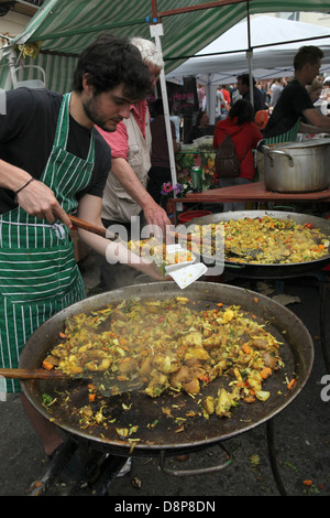Kochen Sie unter Rühren einer großen Pfanne Gemüse und Reis auf einem Straßenmarkt in Brighton Stockfoto