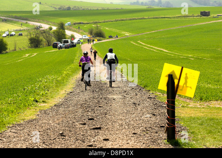 Zwei Radfahrer in Richtung Läufer auf die drei Festungen Herausforderung auf der South Downs Way in West Sussex. Stockfoto