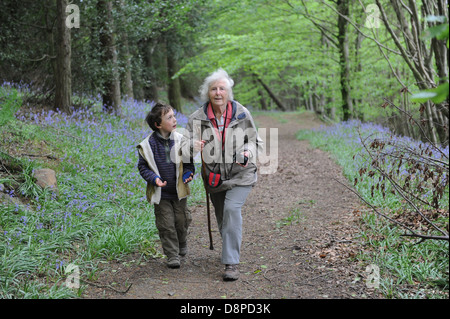 Großmutter und Enkel zu Fuß durch ein Bluebell Holz im Faceby in den North York Moors Stockfoto