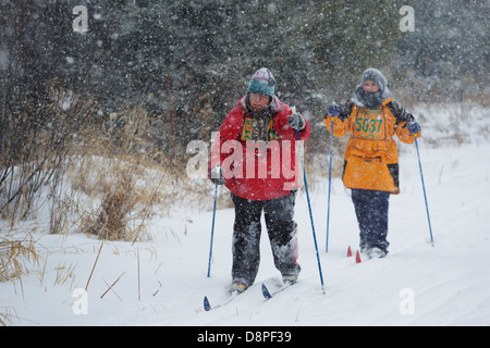 Zwei Skifahrer Ski in der Mora-Vasaloppet während eines Schneesturms am 10. Februar 2013 in der Nähe von Mora, Minnesota. Stockfoto