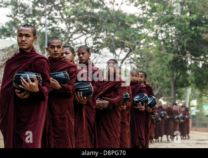 Buddhistische Mönche sammeln von Almosen Schüsseln mit Essen am Morgen von Dorfbewohnern in der Nähe von Bagan Burma Myanmar Stockfoto