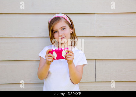 blonde kleine Mode Kind Mädchen mit rosa Smartphone spielen Stockfoto