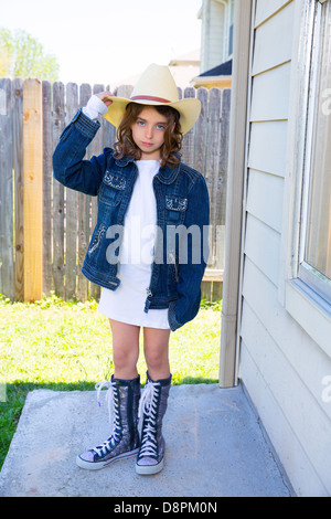 Kleines Kind Mädchen vorgibt, ein Cowboy mit Vater Hut und Jacke Stockfoto