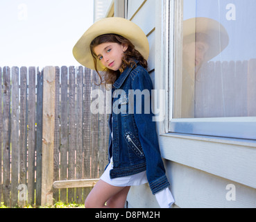 Kleines Kind Mädchen vorgibt, ein Cowboy mit Vater Hut und Jacke Stockfoto