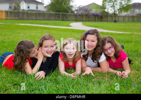 Kinder-Mädchen-Gruppe auf Rasen Rasen lächelt glücklich zusammen hintereinander liegend Stockfoto