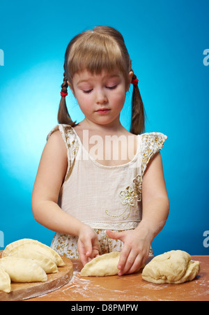 Lächelnd wenig Mädchen kneten Teig in Küche mit eine Torte backen Stockfoto