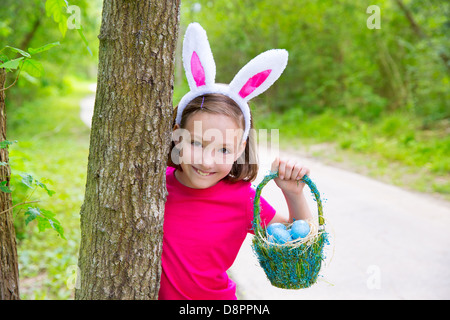 Ostern-Mädchen mit Eiern Korb und lustige Häschen Gesichtsausdruck am Wald Stockfoto