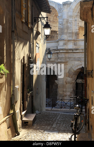 Straße der alten Bezirk Arles mit dem Amphitheater im Hintergrund, Bouches-du-Rhône. Stockfoto