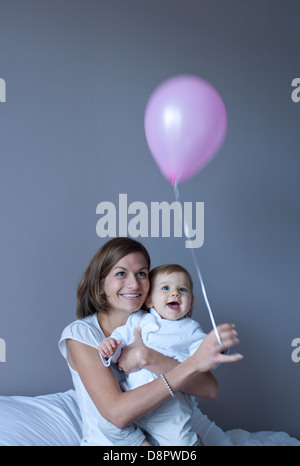 Mutter und Baby spielt mit Ballon Stockfoto
