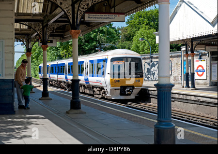 Ein junges Kind winkt ein Chiltern Railways Zug am Bahnhof Chorleywood, Hertfordshire, UK Stockfoto