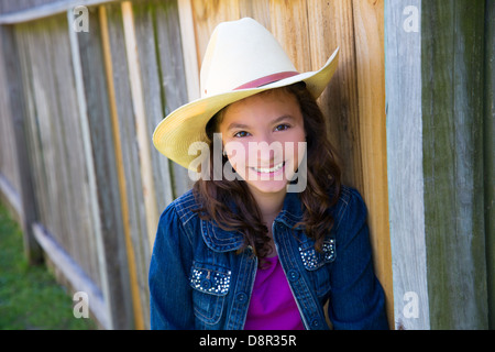 Kleines Kind Mädchen vorgibt, ein Cowboy mit Vater Hut Stockfoto