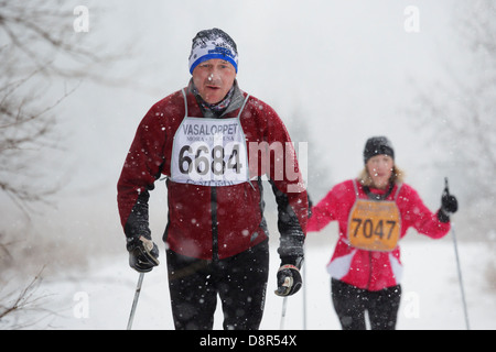 Viel Schnee fällt als Konkurrenten Ski in der Mora-Vasaloppet. Stockfoto