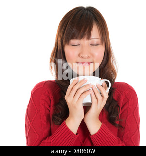 Asiatische Mädchen genießen eine Tasse Kaffee, Kaffee, Rauch, isoliert auf weißem Hintergrund. Schöne gemischte asiatische Modell. Stockfoto