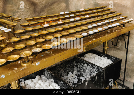 Kerzen in der Ecke eines katholischen Grotte-Schreins Stockfoto