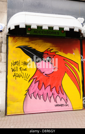 Graffiti auf einem Shop shutter "North Street wird rise Again" mit einem Phoenix nach die North Street Arcade in Belfast zerstört wurde Stockfoto