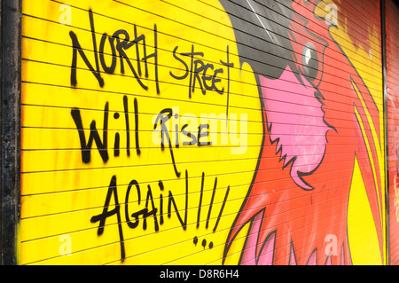 Graffiti auf einem Shop shutter "North Street wird rise Again" mit einem Phoenix nach die North Street Arcade in Belfast zerstört wurde Stockfoto