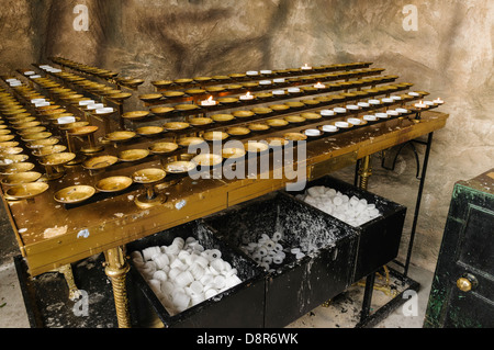 Kerzen in der Ecke eines katholischen Grotte-Schreins Stockfoto