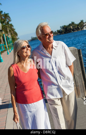 Glücklich senior Mann und Frau romantisch zu zweit zusammen mit Blick auf den tropischen Meer oder Fluss mit strahlend blauem Himmel Stockfoto