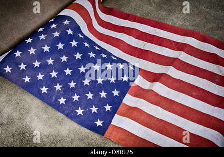 Nahaufnahme von verwitterten amerikanische Flagge auf strukturierte grauen Stoff Stockfoto