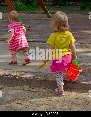 Zwei kleine Mädchen, die zu Fuß am Spielplatz Stockfoto