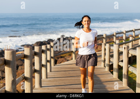 Fit Mitte Alter Frau Joggen am Strand am Morgen Stockfoto