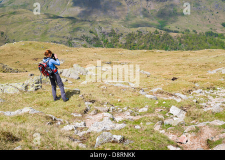 Eine weibliche Wanderer unter einem Foto Whil Abstieg vom Gipfel des Wasdale in Richtung Thornythwaite fiel im Lake District. Stockfoto